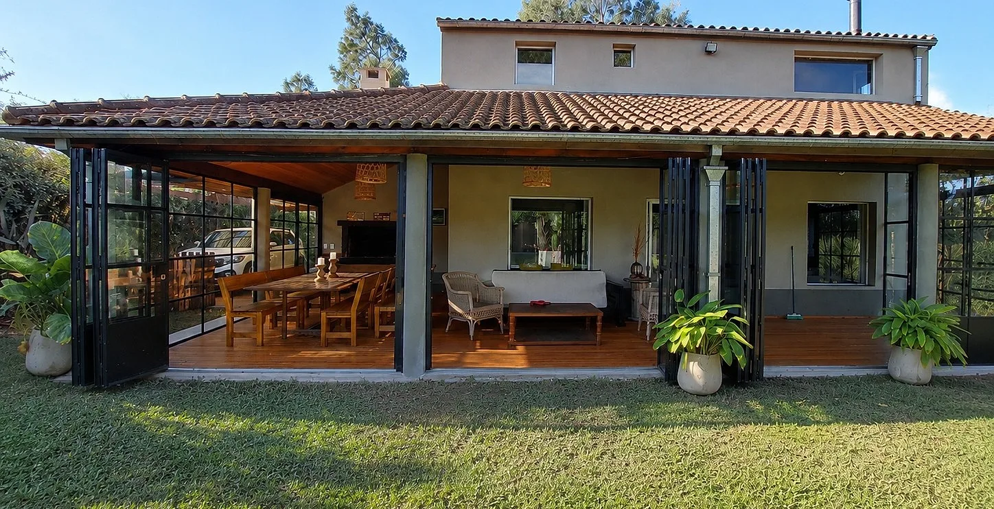 Galería de campo abierta con cerramiento plegable de hierro y vidrio plegado hacia un lado