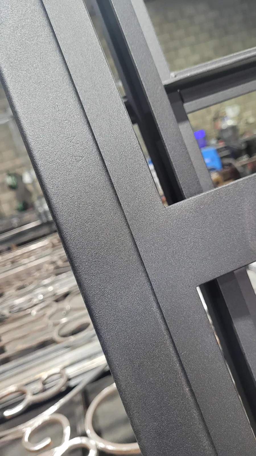 Detalle de la terminación esmerilada y pintada de un cerramiento de hierro, sin masilla